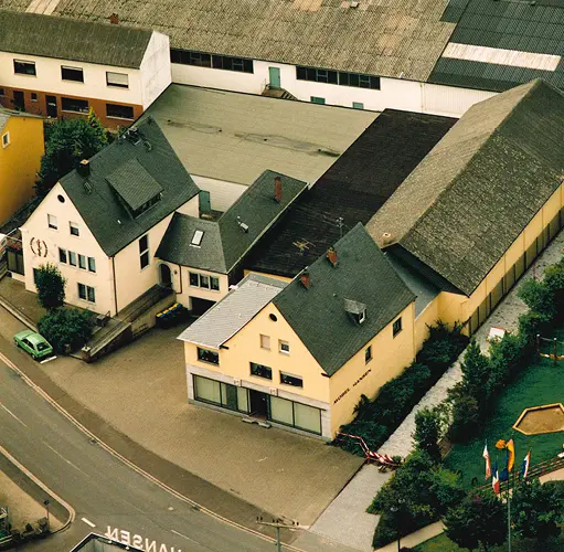 Esszimmer mit großem Esstisch aus Massivholz und sechs braunen Freischwinger-Stühlen auf hellem Parkett – moderne Essgruppe, natürliche Materialien, gemütliches Ambiente für stilvolles Wohnen.